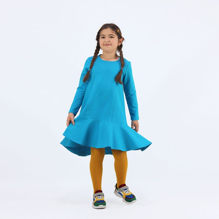 Loose dress is a loose fit dress, that goes wider to the bottom. It is longer on the back with a wide frilled trim at the bottom. Dress is in blue colour. Children, 3 -10 yrs. BonnyJoy - wearing, in front