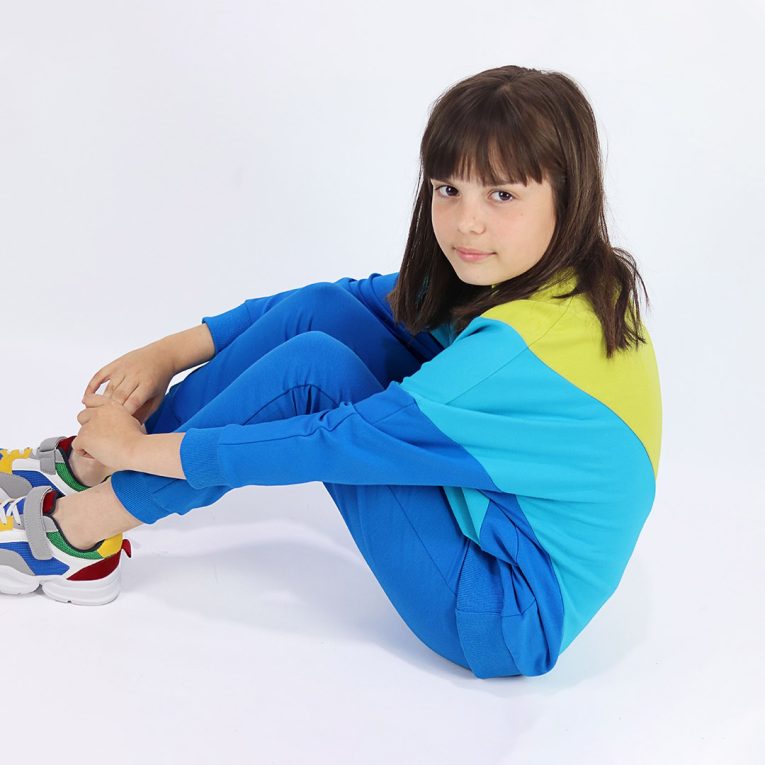 Batwing sweatshirt is a loose fit top with triangular form color blocks. It comes in a combo of three colours - bright lime, electric blue and deep blue. Side view. Children, 3 -10 yrs. BonnyJoy