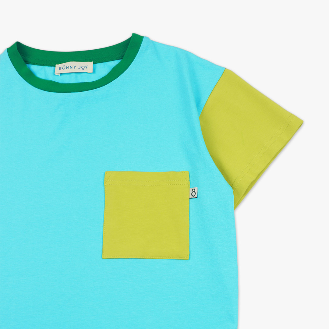 Our colour block t-shirt is a loose fit top with square pocket on the left and a little longer on the back. The front and the back in blue colour, right sleeve in electric blue, left sleeve and the pocket - in bright lime. On the neck - green colour. Front view, close-up. Children, 3 -10 yrs. BonnyJoy