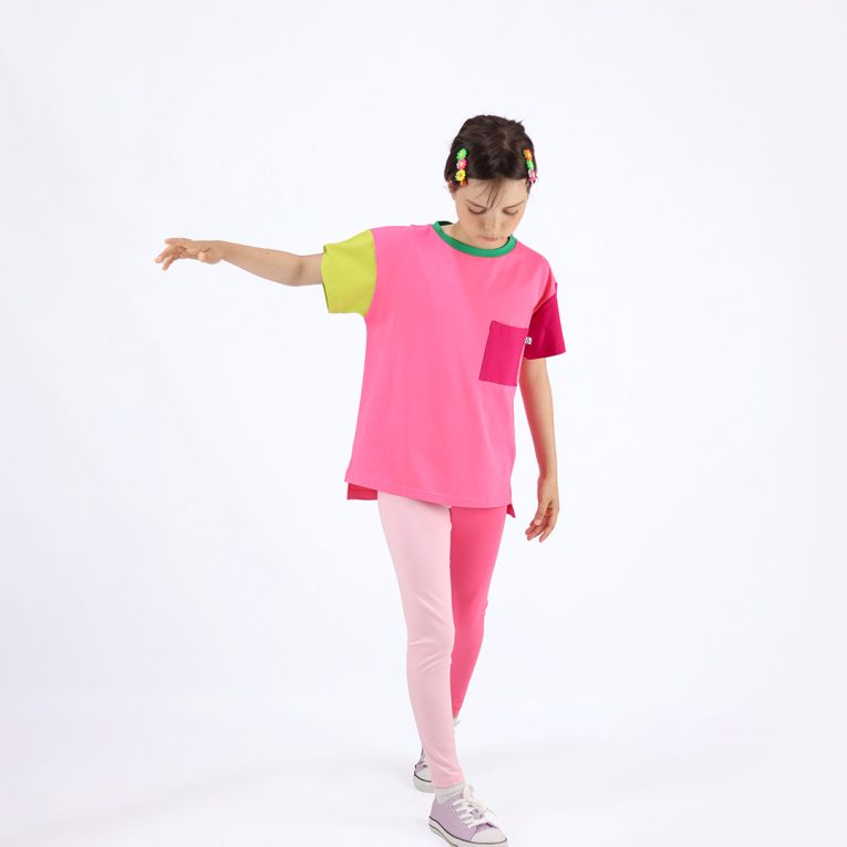 Our colour block t-shirt is a loose fit top with square pocket on the left and a little longer on the back. The front and the back in pink colour, right sleeve in bright lime, left sleeve and the pocket - in raspberry. On the neck - green colour. Front view. Children, 3 -10 yrs. BonnyJoy