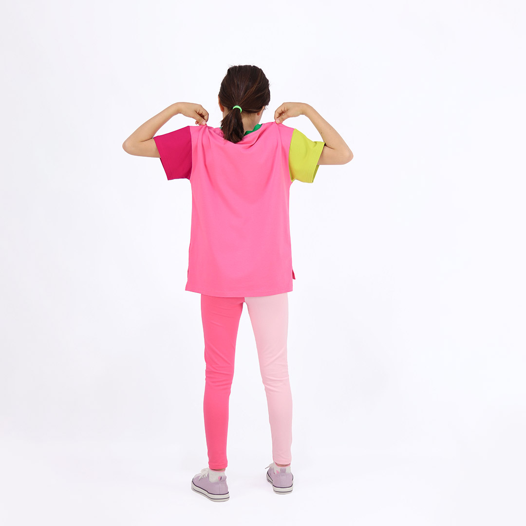 Our colour block t-shirt is a loose fit top with square pocket on the left and a little longer on the back. The front and the back in pink colour, right sleeve in bright lime, left sleeve and the pocket - in raspberry. On the neck - green colour. Back view. Children, 3 -10 yrs. BonnyJoy