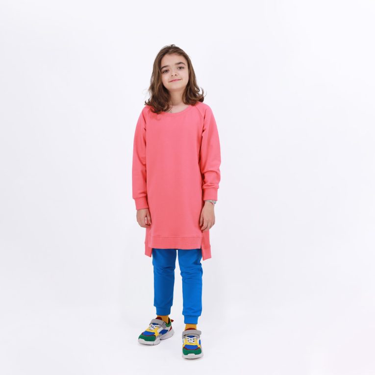Cylinder dress is a one-colour loose fit dress with round pockets aside and a little longer on the back in salmon colour. One more front view. Children, 3 -10 yrs. BonnyJoy
