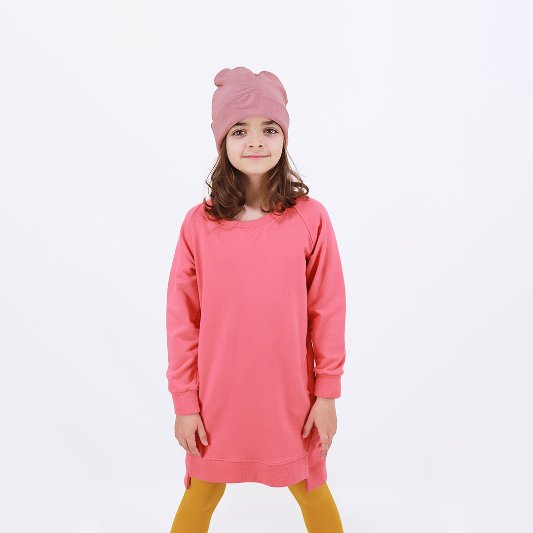 Cylinder dress is a one-colour loose fit dress with round pockets aside and a little longer on the back in salmon colour. Another front view. Children, 3 -10 yrs. BonnyJoy