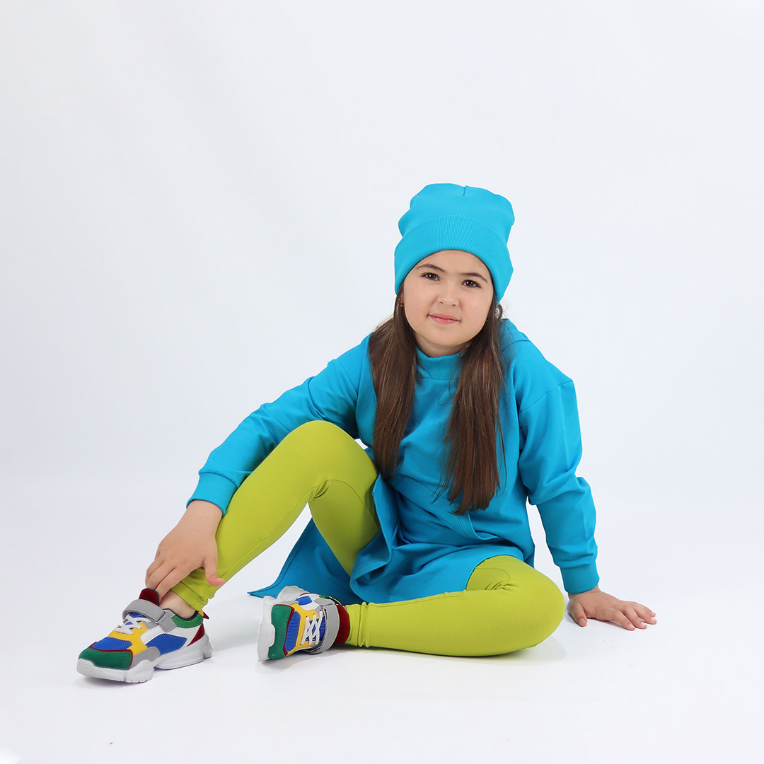 Joyful leggings are absolutely classic leggings in bright lime colour. Front view, a girl sitting. Children, 3 -10 yrs. BonnyJoy