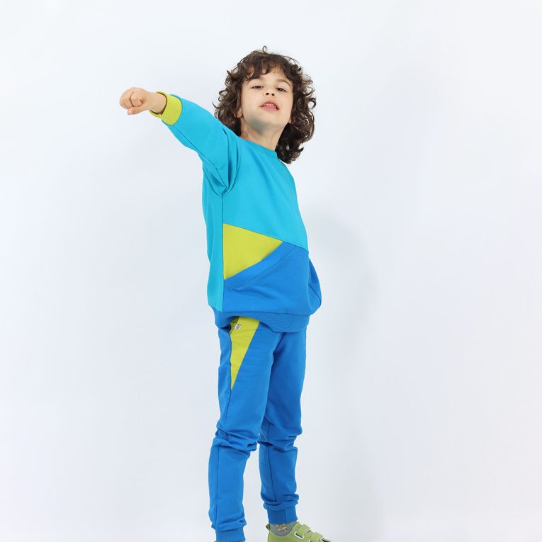 Slim Fit Colour Block Joggers are a pair of sweatpants in deep blue with two Italian type side pockets in different colours - bright lime and salmon. It features ribbed waist and cuffs. Side view. Children, 3 -10 yrs. BonnyJoy