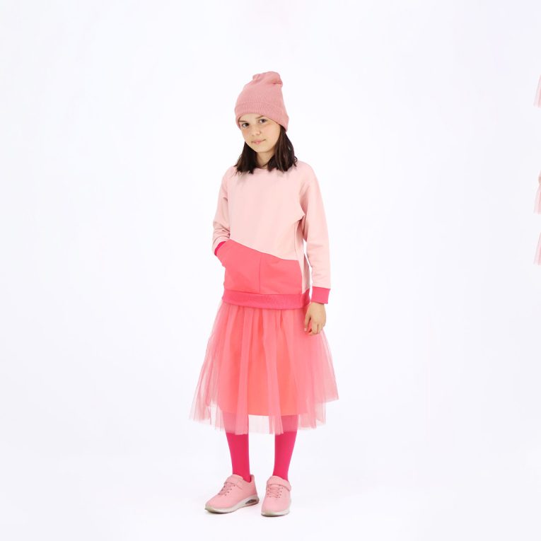 Our tulle skirt is a loose falling skirt made from tulle outside and jersey inside in salmon colour. Front view. Children, 3 -10 yrs. BonnyJoy