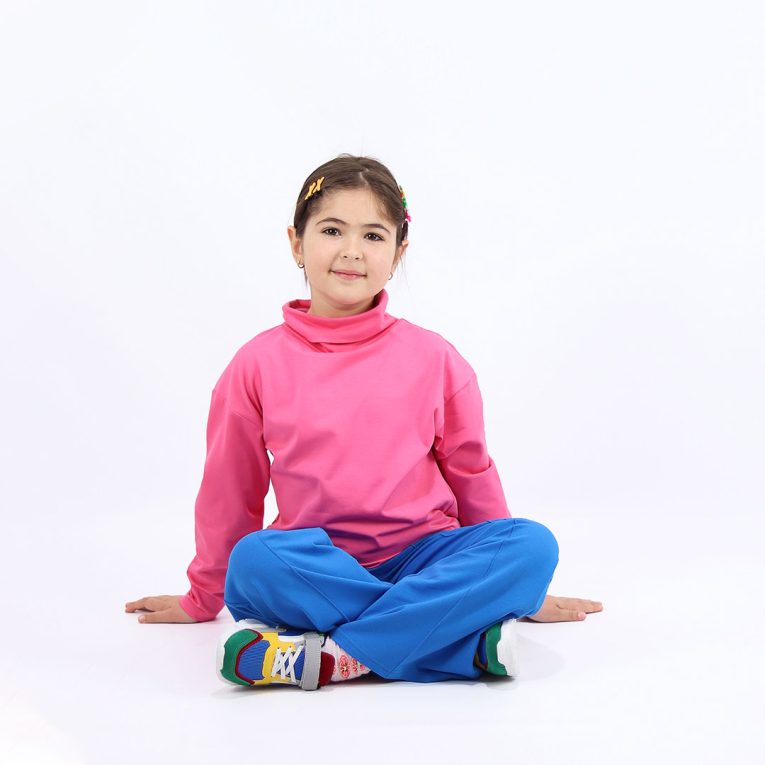 Turtleneck loose top is a classic top loose on the neck in pink colour. Another front view, a girl sitting. Children, 3 -10 yrs. BonnyJoy