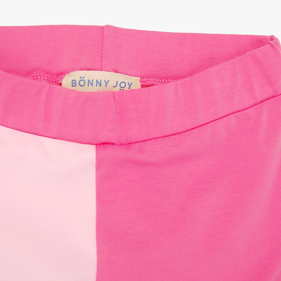 Two-colour leggings with two different colour legs. Left leg is light pink, right leg is pink and light pink weist. Front view, close-up. Children, 3 -10 yrs. BonnyJoy