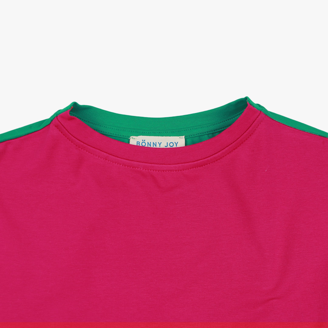 Our two-way top is a loose fit top with short sleeves in two colours. On one side is raspberry, on the other - green colour. You could wear it front on the back and the other way round. Raspberry in front, close-up. Children, 3 -10 yrs. BonnyJoy